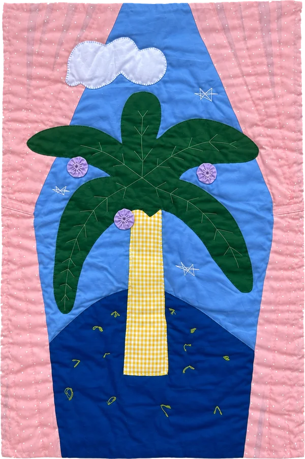 Quilt with a green palm tree beneath a white cloud, framed in pink.
